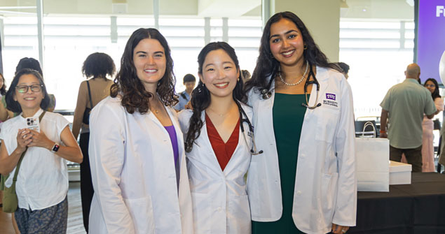 Medical students watch an instructor demonstrate a procedure using a pediatric patient simulator